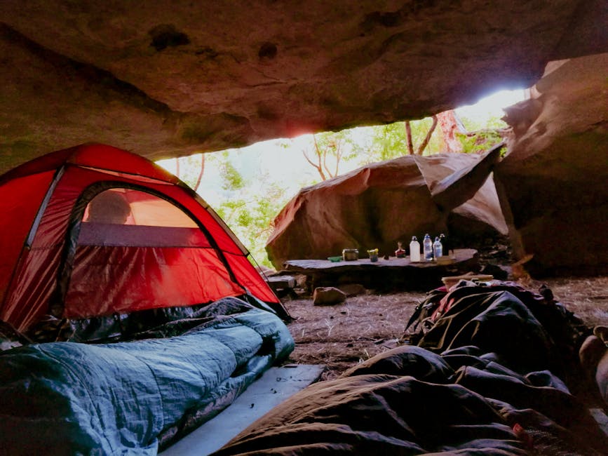 Explore the serenity of cave camping with a red tent in a natural setting, capturing relaxation and adventure.